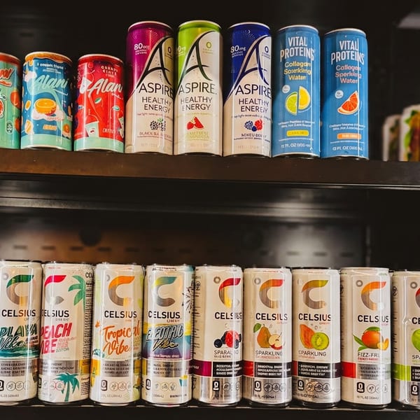 Two shelves filled with colorful energy drinks and sparkling waters in various flavors and brands.